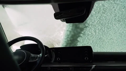 A car service worker washes the windshield of a car. View from the cabin Vídeos de archivo 235597146