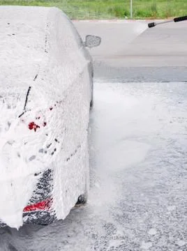 Car on the side in the foam and bubbles from the detergent in the car wash Stock Photos