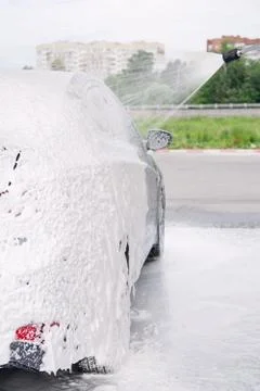 Car on the side in the foam and bubbles from the detergent in the car wash Stock Photos
