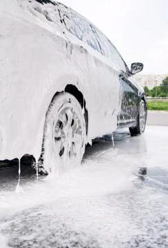 Car on the side in the foam and bubbles from the detergent in the car wash Stock Photos