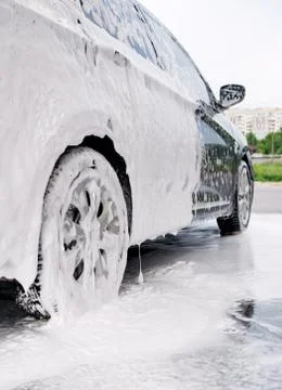 Car on the side in the foam and bubbles from the detergent in the car wash Stock Photos