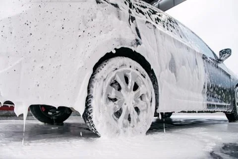 Car on the side in the foam and bubbles from the detergent in the car wash Stock Photos