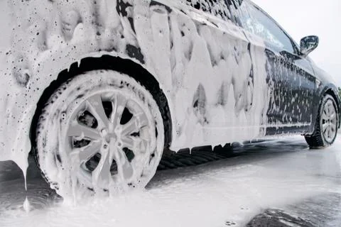 Car on the side in the foam and bubbles from the detergent in the car wash Stock Photos