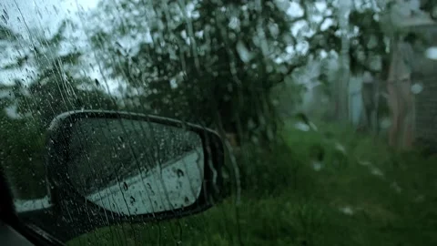 Car side mirror covered in raindrops on gloomy rainy day. ?lose-up view thr.. Stock Footage 341324290
