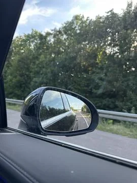 Car Side Mirror Reflection on Forest Road Travel Concept Stock Photos
