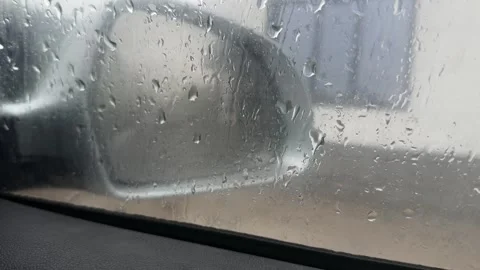Car side mirror seen through wet window with rain drops Stock Footage 335694489