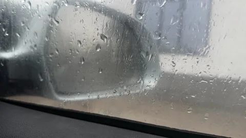 Car side mirror seen through wet window with rain drops Stock Footage 336959568