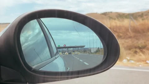 Car Side Mirror View of Highway Approaching Distant Toll Booth Stock Footage 339753088