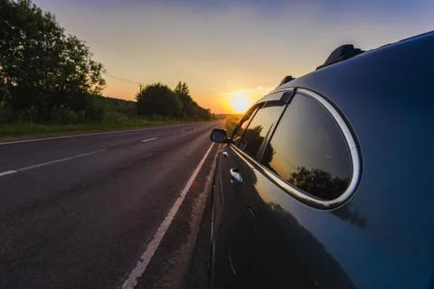 Car on the side of the road sunset Foto stock