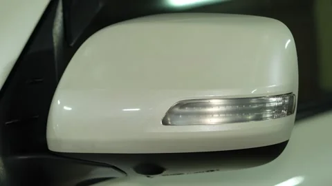 Car side view mirror assembly featuring a pearl white housing and an integrat Stock Footage 344598362