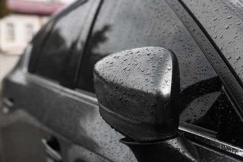 Car with side view mirror in drops of water outdoors, closeup Stock Photos