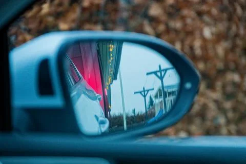 Car side window reflection of gray car and red building Photos