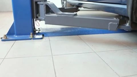 The car slowly rises in the elevator, bottom view. Repair of a vehicle indoors. Stock Footage 165836570