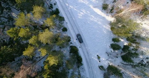 Car on a small winter forest road, C4k aerial, top down, drone shot, followin Stock Footage 113723839
