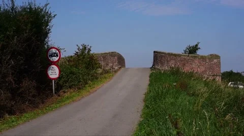 Car sounding warning horn approaching blind summit of humpback bridge uk Stock Footage 67535458