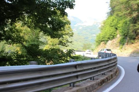 Car speeding around corner in green mountains Stock Photos
