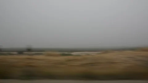 Car speeding on a road through green fields - side window blurred motion view Stock Footage 109404157
