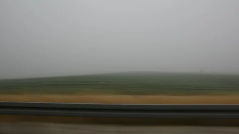 Car speeding on a road through green fields - side window blurred motion view Video stock 109404431