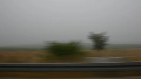 Car speeding on a road through green fields - side window blurred motion view 스톡 동영상 109404452