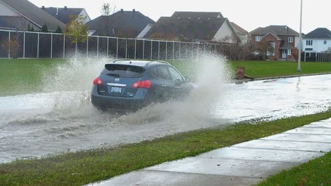 Car speeds through huge puddle on flooded street Nov 12 2017 Ottawa ON Stock Footage 90611359