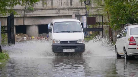  A car splashing water while passing through flooded road  Stock Footage 241494715