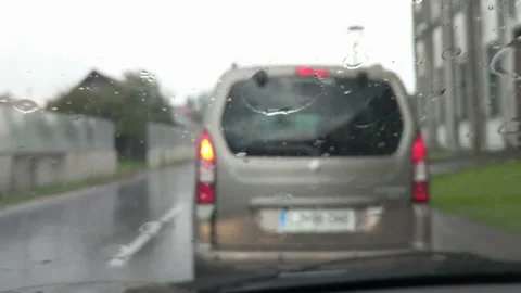 Car standing in stopped traffic during rush hour on a rainy cloudy day. Video stock 137879716