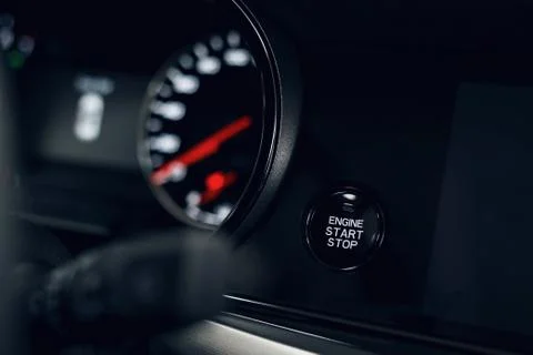 Car Start-Stop Engine Button of a modern car in the interior of the expensive Stock Photos