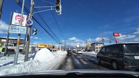Car starts from traffic light through commercial area in Hakodate winter Video stock 333069467