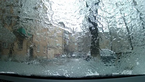 The car is stationary. snow on the windshield.wipers clean snow from the glass. Video stock 123571908