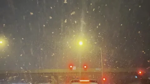 Car Stopped at Red Light During Nighttime Snowfall Stock Footage 340557579