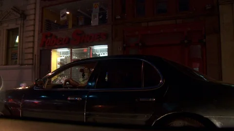 Car stopped at traffic light with driver's hand on steering wheel, night. Stock-Footage 108060452