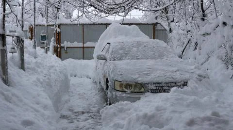 A car stuck in deep snow in a private yard Фото
