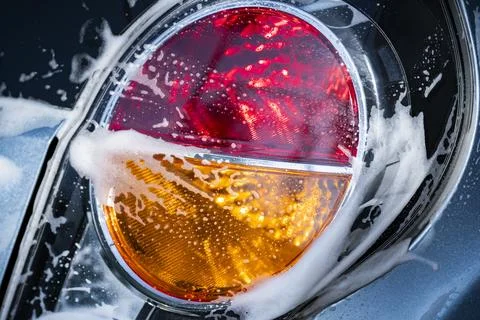 Car Tail Light Covered with Soap Foam During Vehicle Wash Foto stock