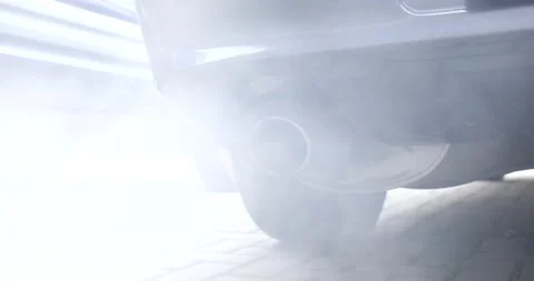 Car tailpipe or exhaust pipe tip emitting smoke. Standing nondescript car Stock Footage 238014029
