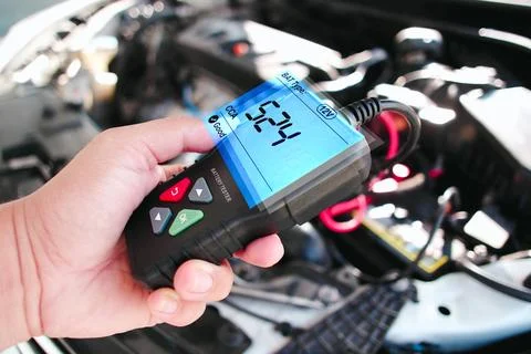 Car technician checking CCA Cold Cranking Amp of car battery with battery tester Stock Photos