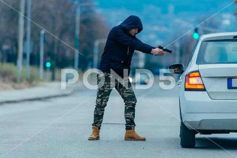 The car thief is pulling the car owner out of his car and trying to get the c Stock Photos