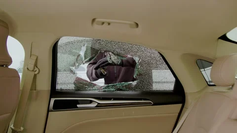 Car thief shattered side window from inside view act of vandalism vehicle crime Stock Footage 276091897