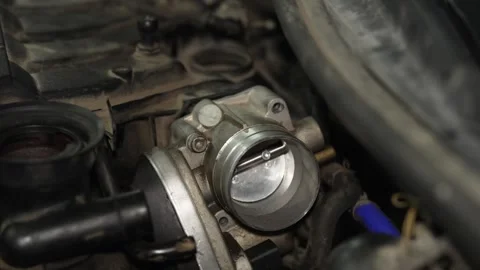 Car throttle body assembly installed on engine inside dusty bay. Stock Footage 341486837