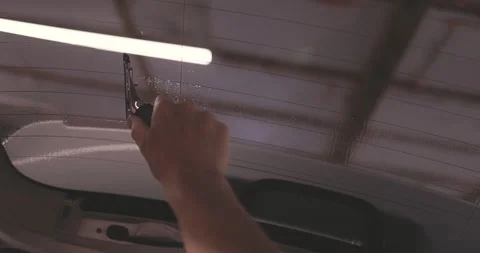 Car tinting windows services Worker specialist apply tint foil on car window Stock Footage 338431843