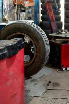 Car tire mounted on a balancing machine in a workshop Stock Photos