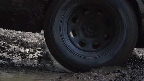 Car tire stuck in deep mud spinning very fast in slow motion Stock Footage 107930885
