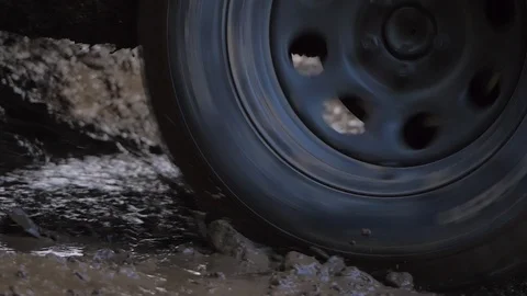 Car tire stuck in deep mud close up spinning very fast getting out slow motion Vidéo 107931055