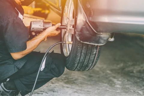 Car tire wheel replace and mechanic staff worker working in garage 스톡 사진