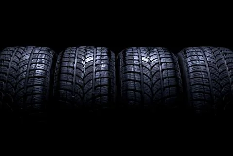 Car tires on black background Stock Photos