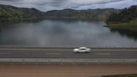 Car Tracking on a Highway Bridge Over a Lake California Drone View Stock Footage 142774190