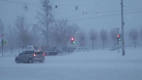 Car traffic in the city in the evening during snowfall in winter, slow motion Stock-Footage 314429525