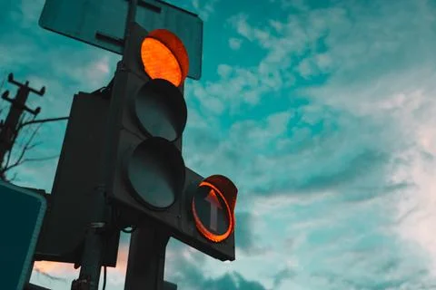 Car traffic light, with a red burning arrow, against the sunset sky Stock Photos