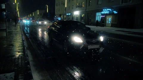 Car traffic at night, falling snow, slow motion Stock Footage 106795823