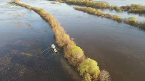 Car with a trailer is moving along a flooded road Stock Footage 190993207