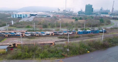 Car Transport Train Loaded With New Vehicles Passing Steelworks, Elevated Shot Stock Footage 340299977